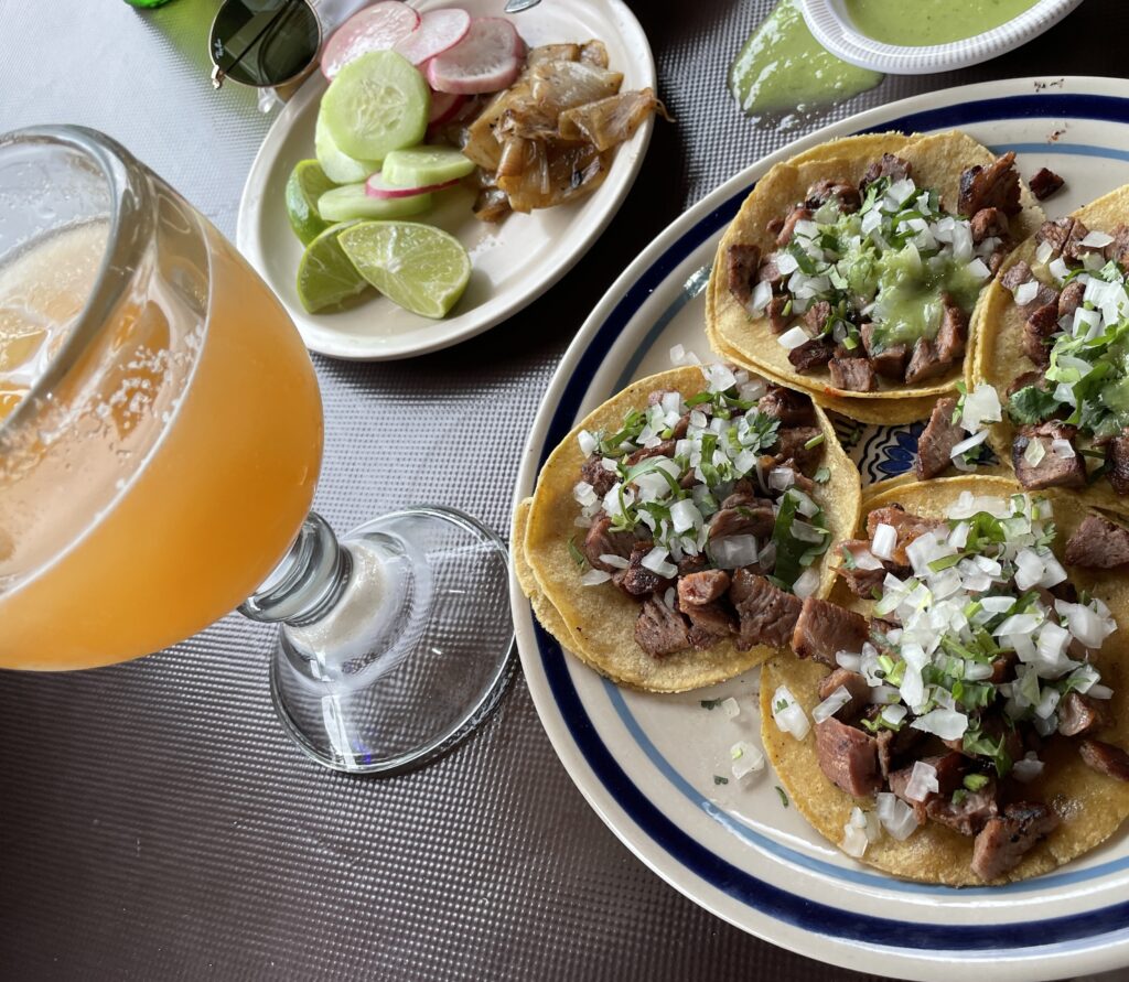 a plate full of chorizo tacos and a large melon drink at Taqueria Viva Mexico in Playa Del Carmen