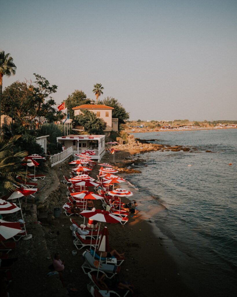 a few locals sitting on a small beach shoreline in Side, Turkiye 