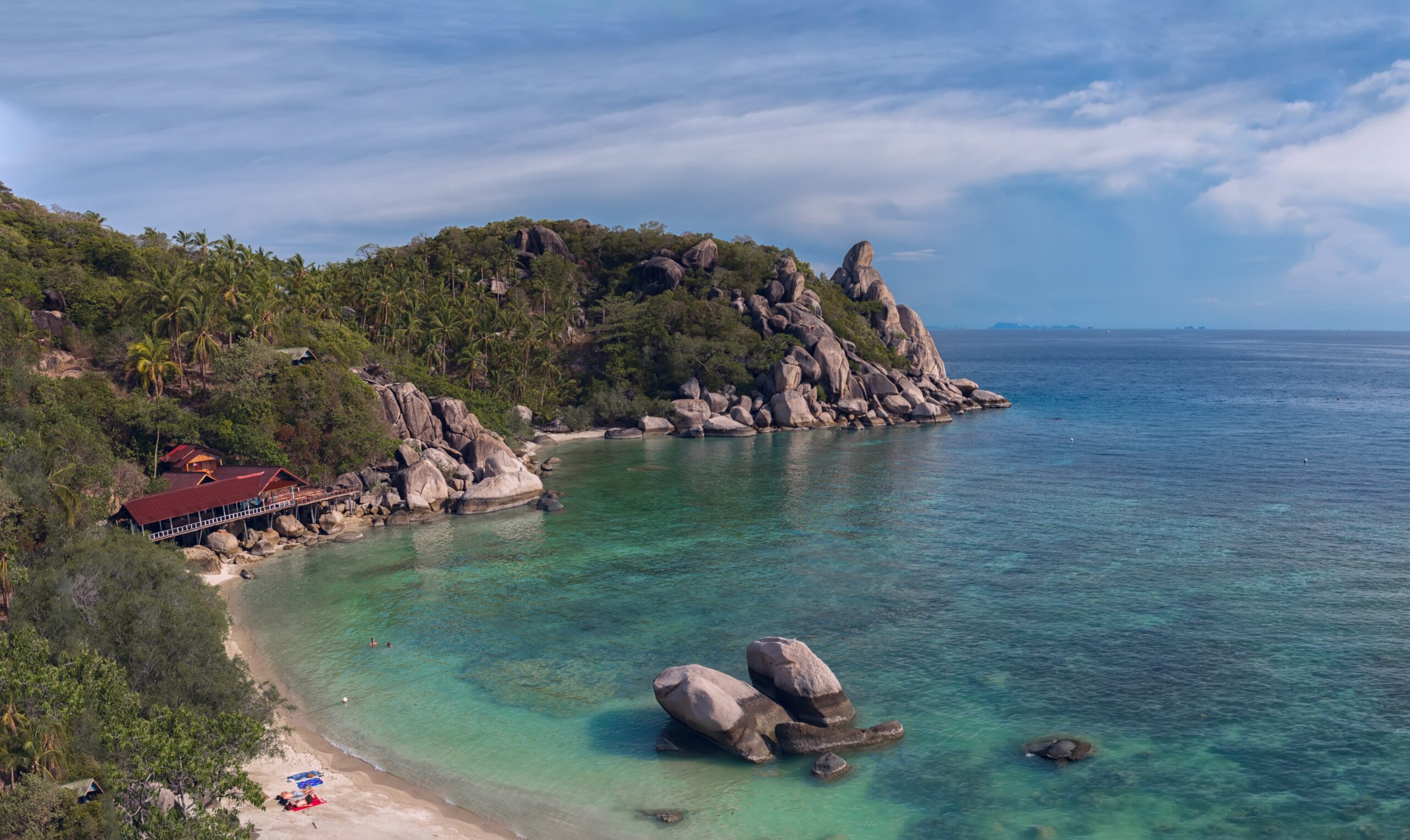 several shades of turquoise water and luscious green hills in Thailand