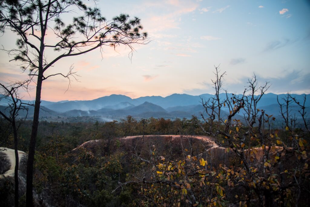 views of canyon trail among several mountains in the distance at sunset in Pai, Thailand 