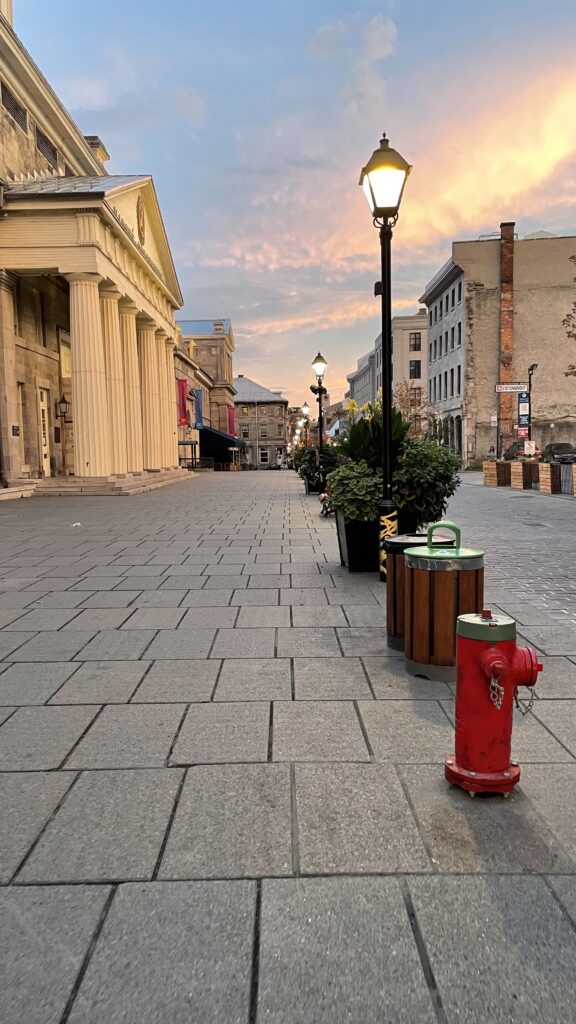 beautiful sunset on a cobblestone street among several beautiful french=inspired architecture