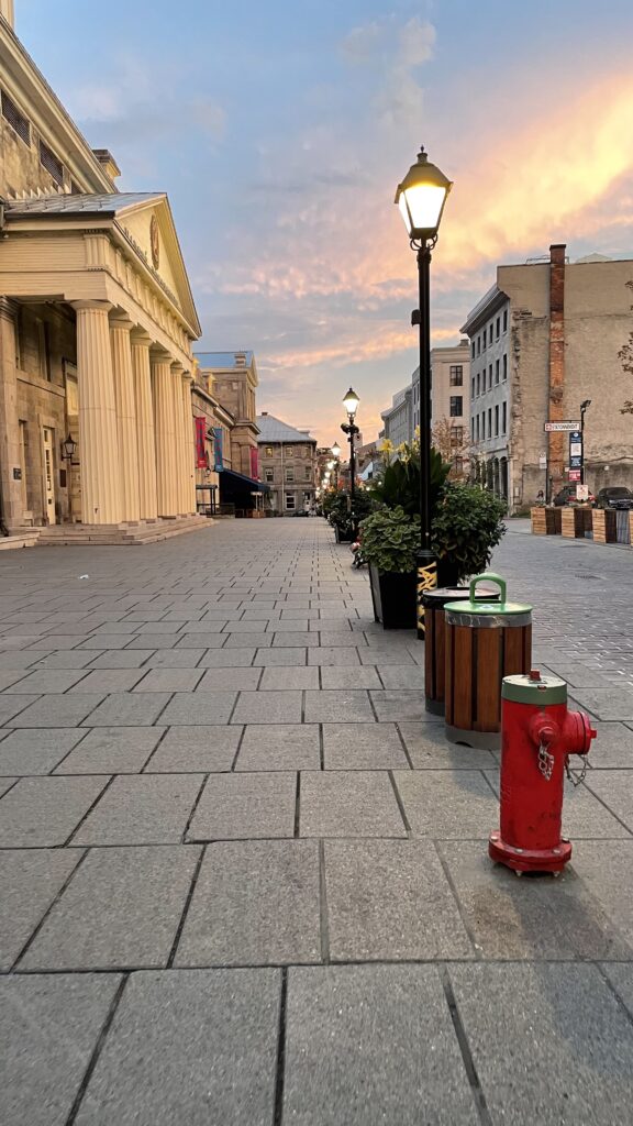 beautiful sunset on a cobblestone street among several beautiful french=inspired architecture 