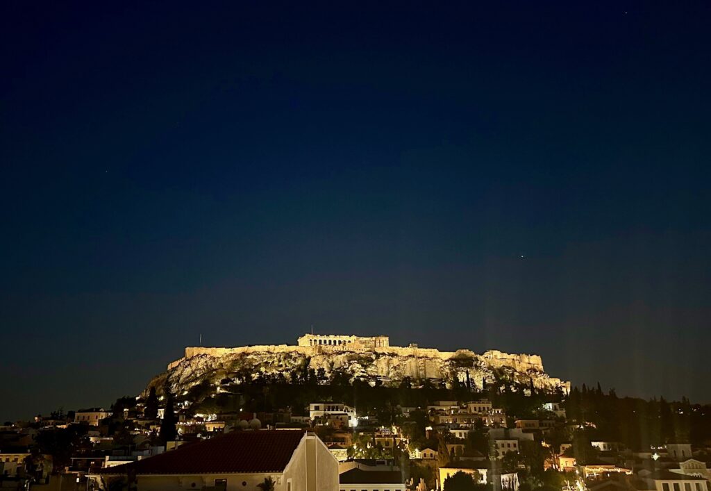 Rooftop views of the famous Parthenon lit up at night in Athens, Greece 