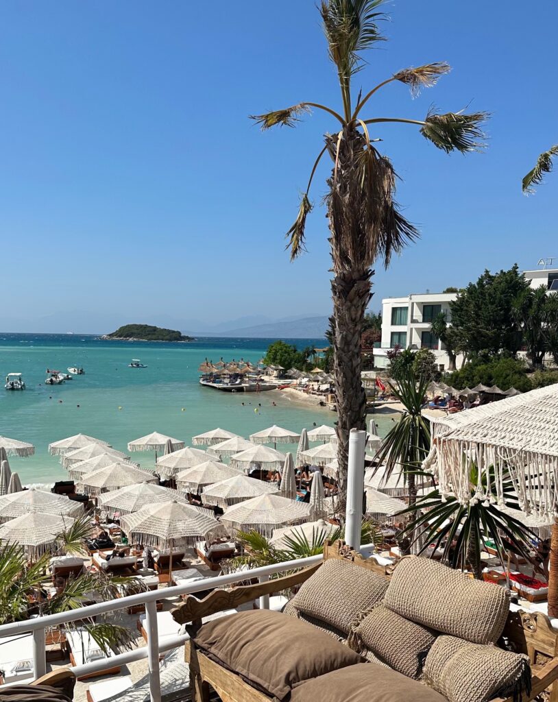 several umbrellas and sunbeds on a crowded beach in Ksamil, Albania 