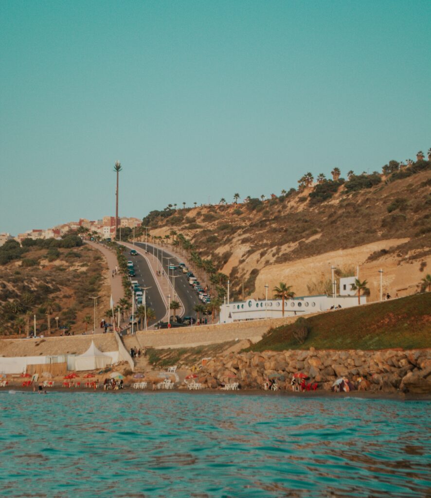 several cars driving down a highway located against the coast in Morocco