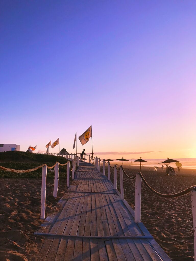 wooden walkway towards the beach in El Jadida, Morocco at sunset 