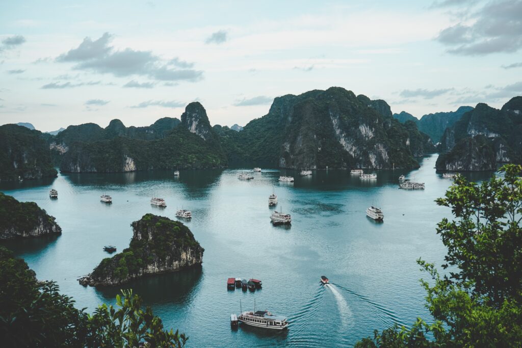 aerial view of boats sailing along the many large limestones in the waters of Ha Long Bay in Vietnam 