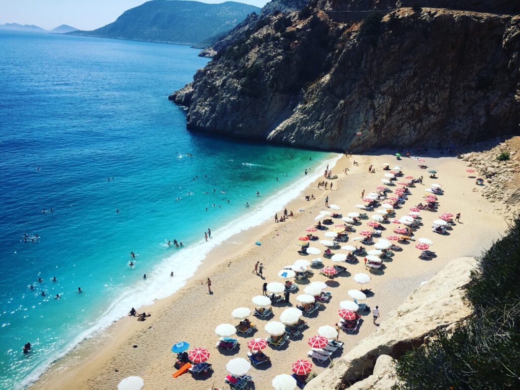 several sun beds and umbrellas lined up along the stunning Kaputas Beach in Kas, Turkey 
