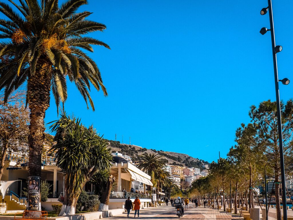 scenic marina full of shops and palm trees in Saranda, Albania 