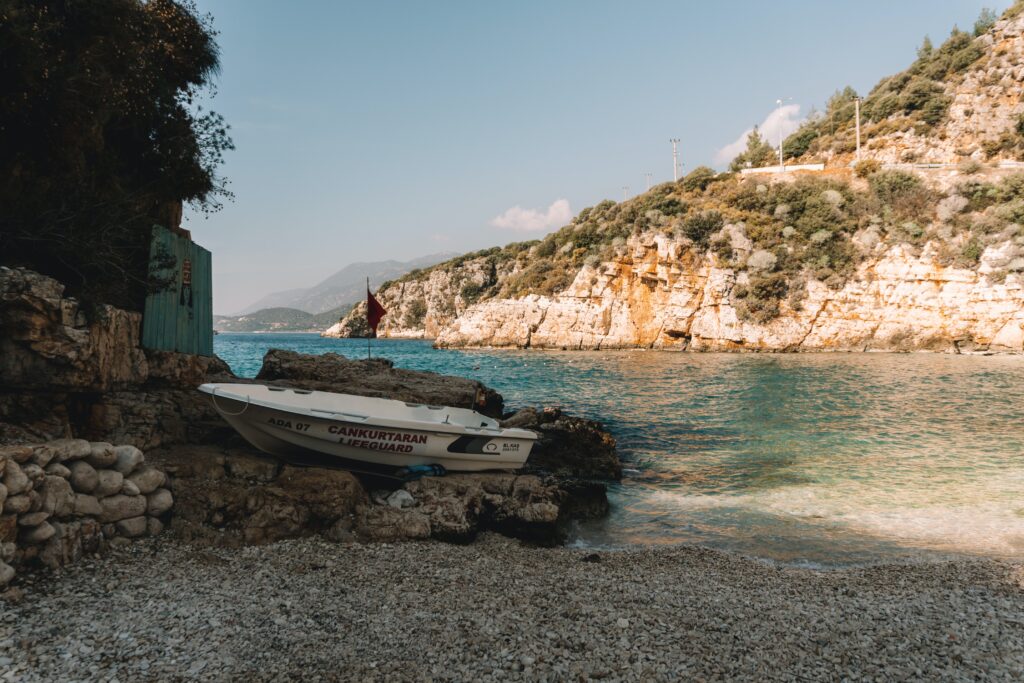 small boat planted along the rocks on a small beach in Kas Turkey 