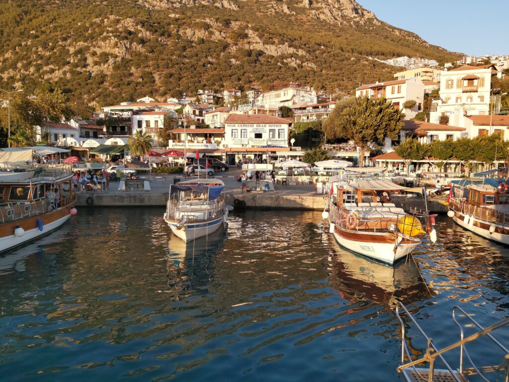 many tourist walking by the main marina in Kas where several boats docked  