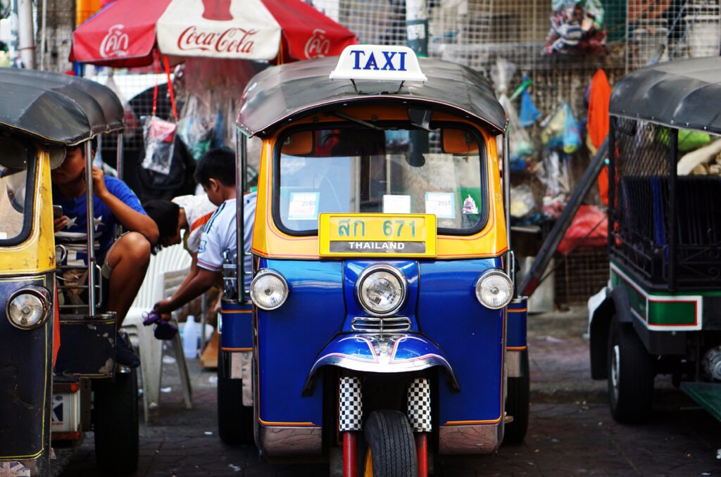 classic blue tuktuk driving on the streets in Thailand
