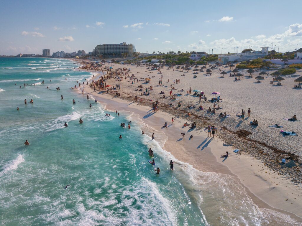 several tourists swimming in the beautiful turquoise beaches of Cancun, Mexico