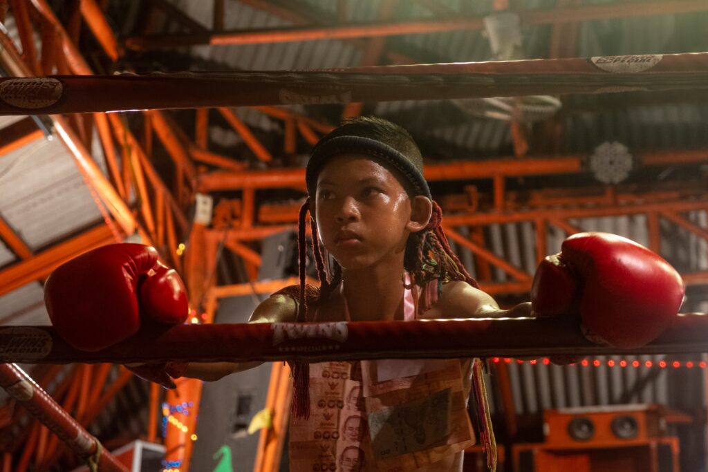 fighter resting along the ropes of a boxing ring in Koh Samui, Thailand