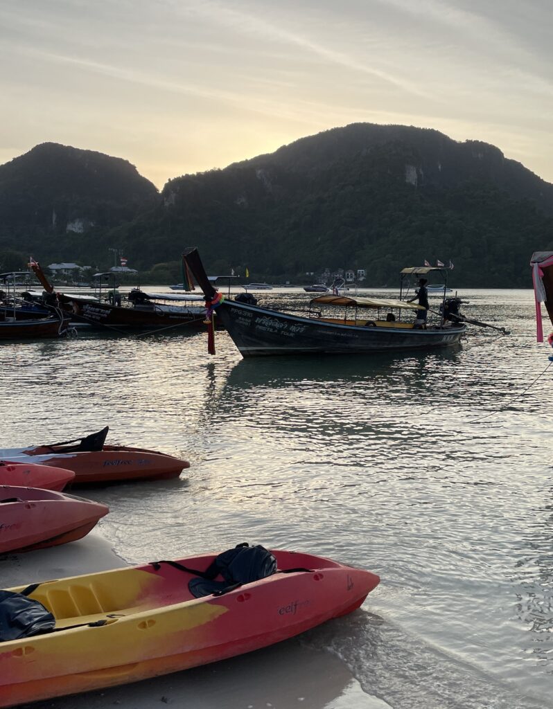 kayaks along the beach shoreline at sunset in Phi Phi Islands, Thailand