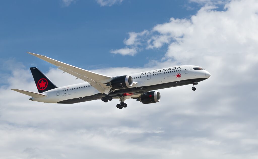 an Air Canada plane flying on a clear skies day in Canada