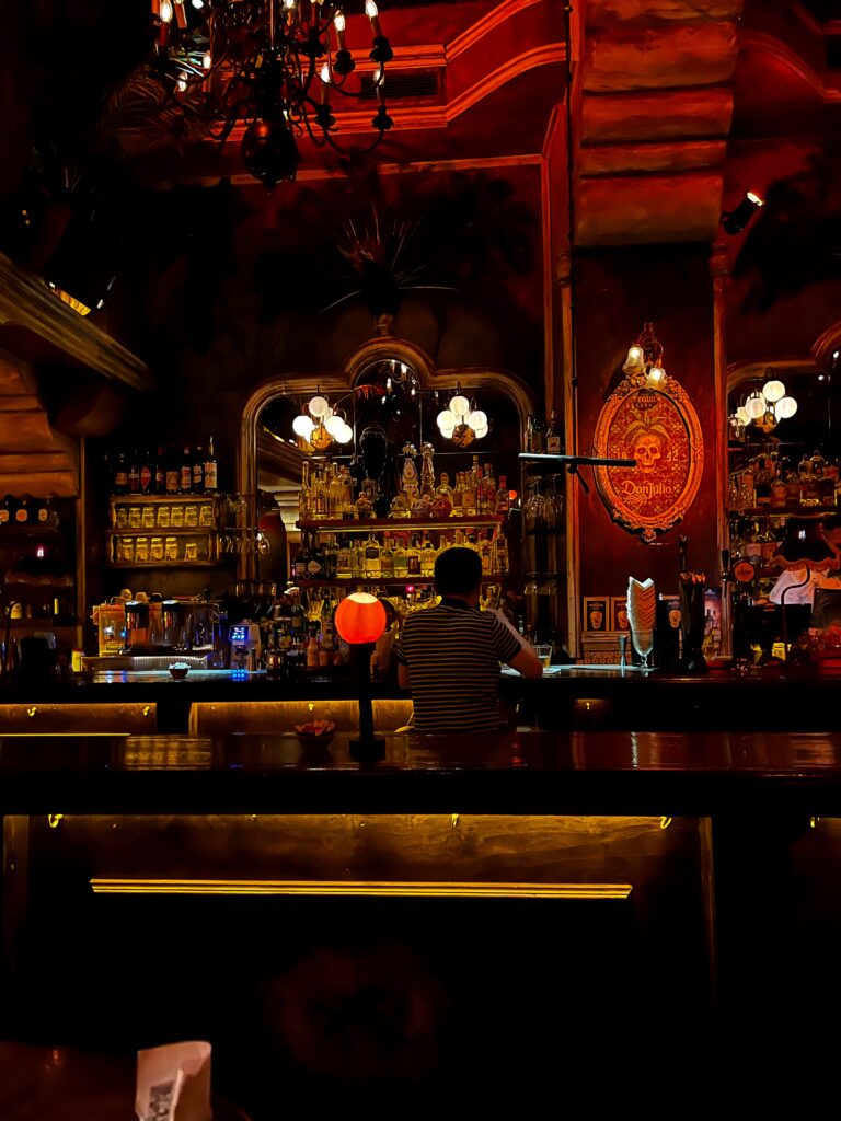 bartender making a drink in a dimly lit bar in Athens, Greece