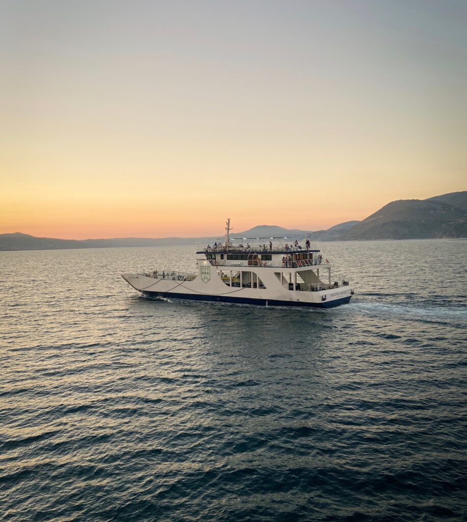 ferry crossing the sea going to an island during sunset in Greece