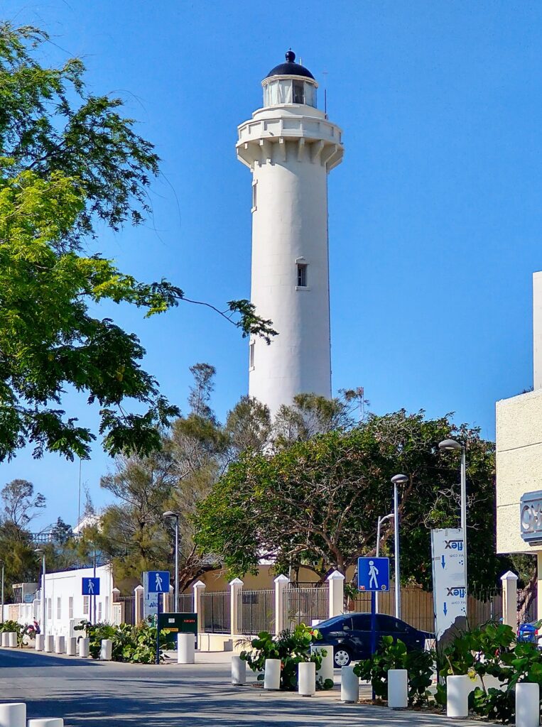 a tall standing white light house in the town of Progreso, Mexico 