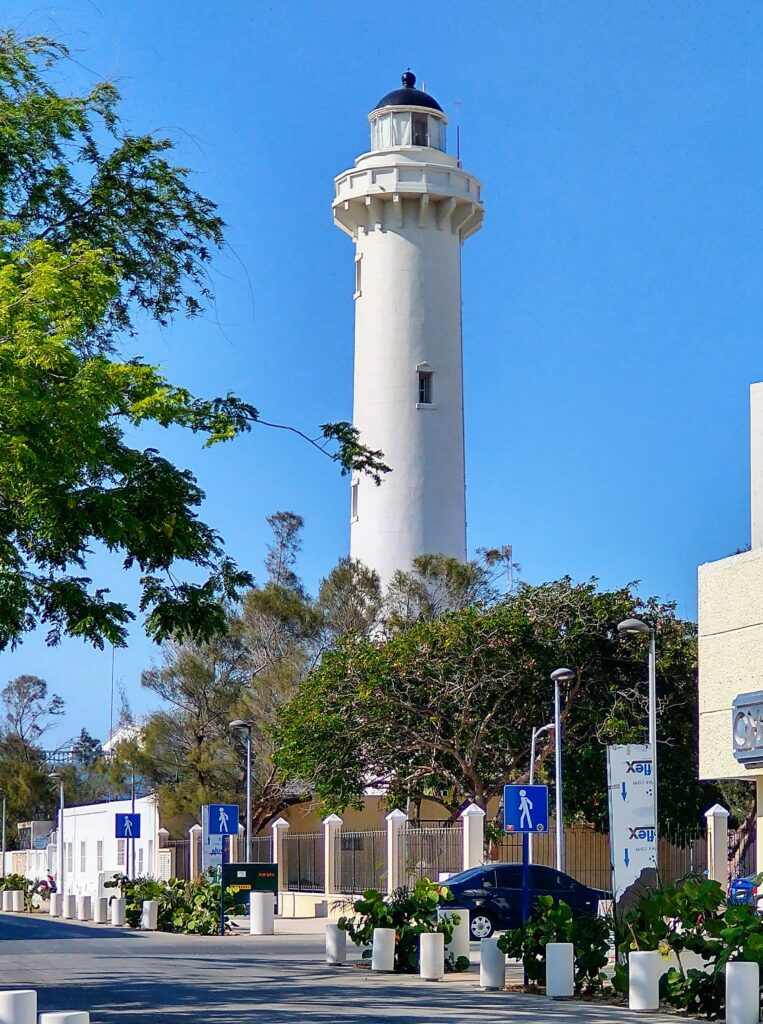 a tall standing white light house in the town of Progreso, Mexico