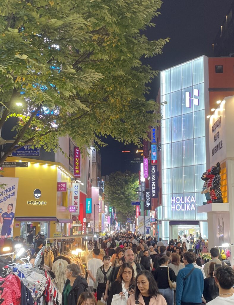 a crowded busy street full of locals and tourists in the evening visiting the Myeongdong Night Market