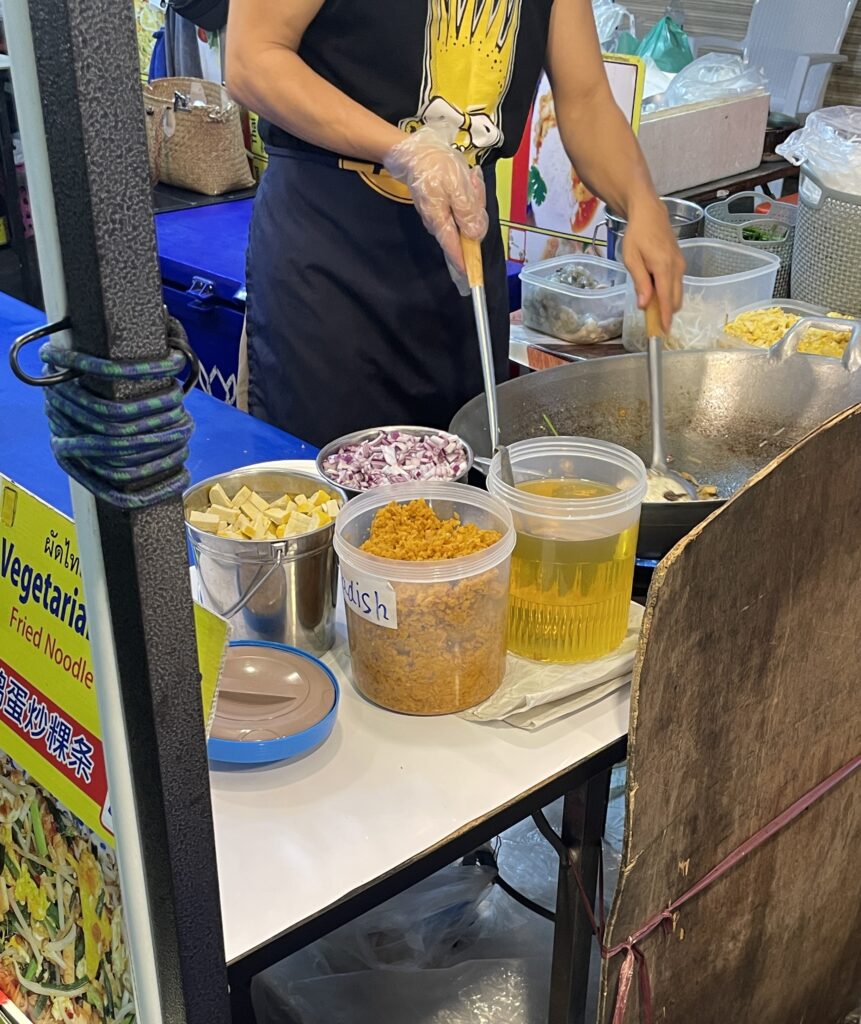 woman cooking a fresh pad thai at the night market in Chiang Mai 