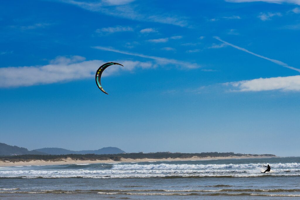 local parasailing along the waters on a sunny day in Viana do Castelo, Portugal