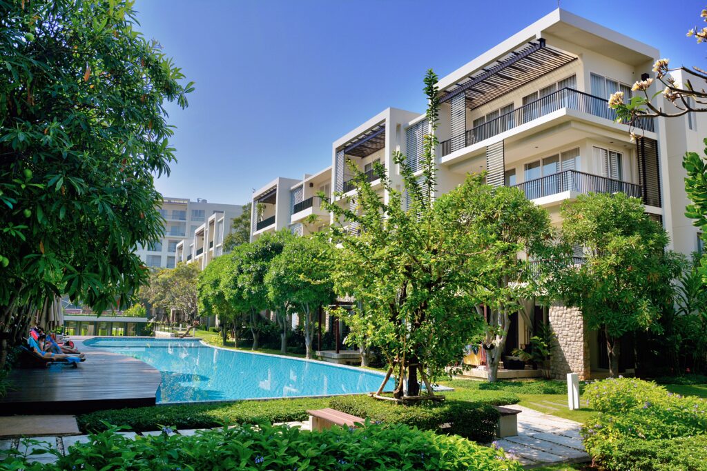 three level story hotel with a pool on a bright sunny day in Hua Hin