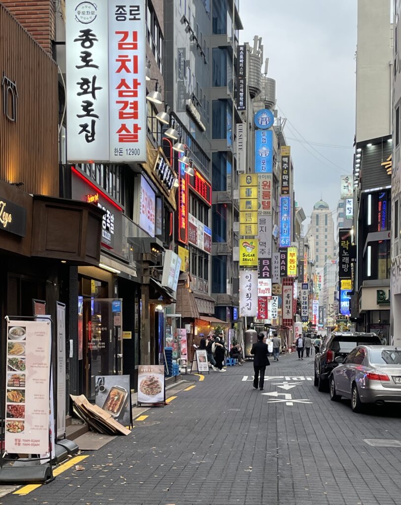 popular street in the Myeongdong area full of bright coloured signage for restaurants and businesses