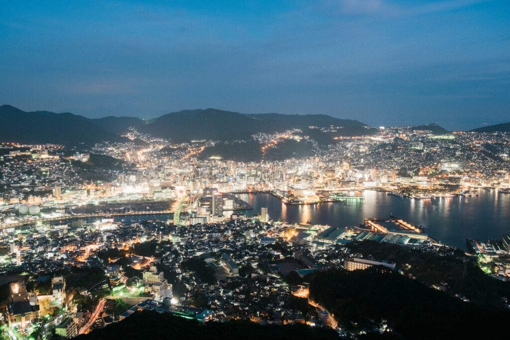panaormic views of the many lit up buildings at night in Nagasaki, Japan