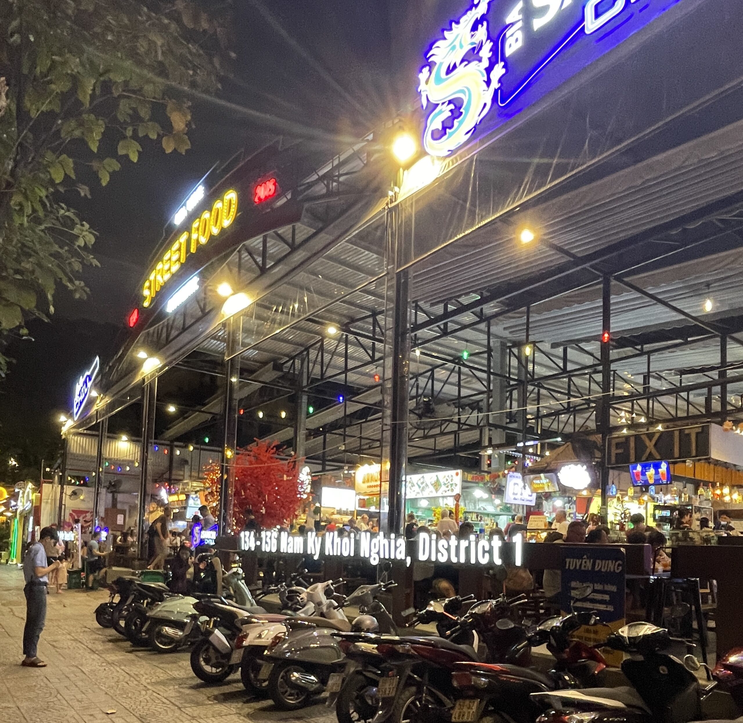 plenty of motorbikes parked outside the popular Ben Nghe Street Food Market in Ho Chi Minh City during the evening