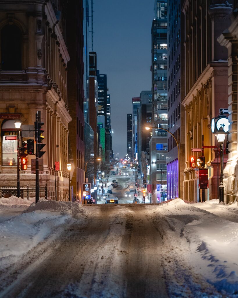 a snow filled street with many city lights in Old Montreal during the Winter 