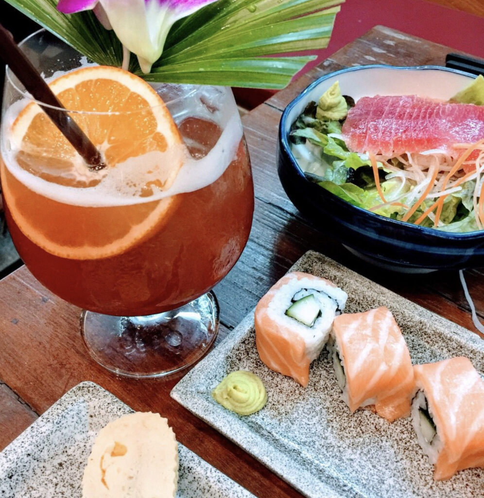 a tropical cocktail and fresh sashimi sushi rolls being served at red snapper restaurant in Kata Beach 