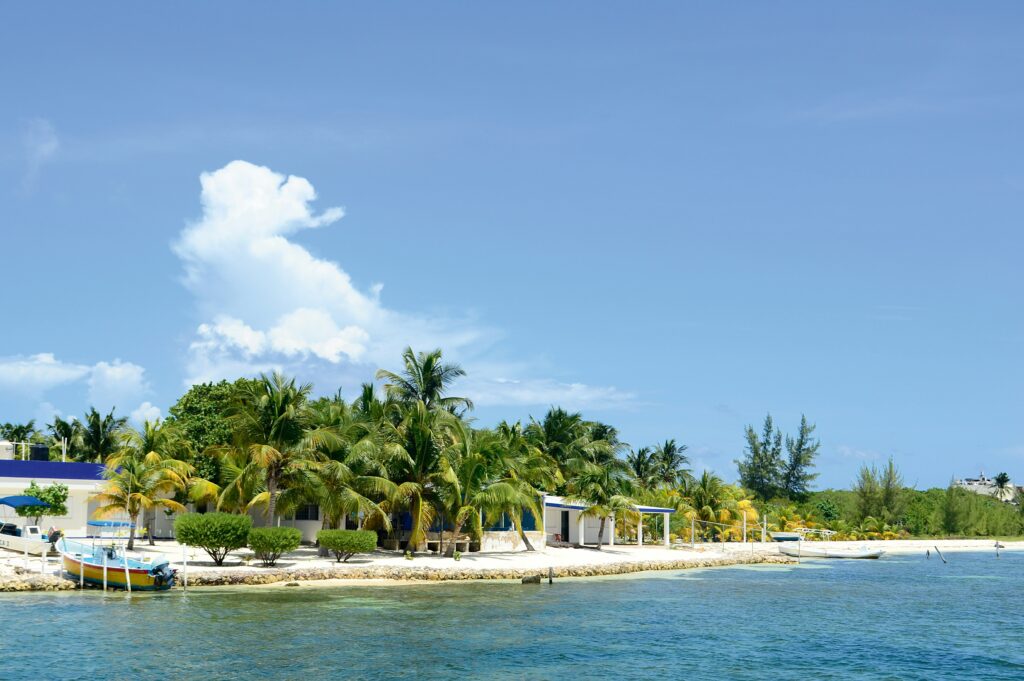 quiet white sandy beach on a clear day in Isla Mujeres / scams in Isla Mujeres