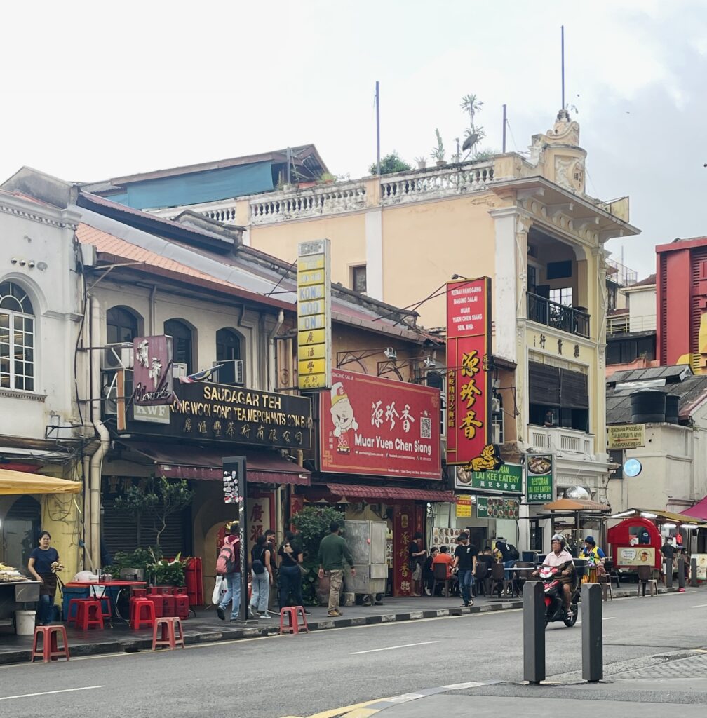 a local man driving his scooter through Chinatown in Kuala Lumpur in the evening 