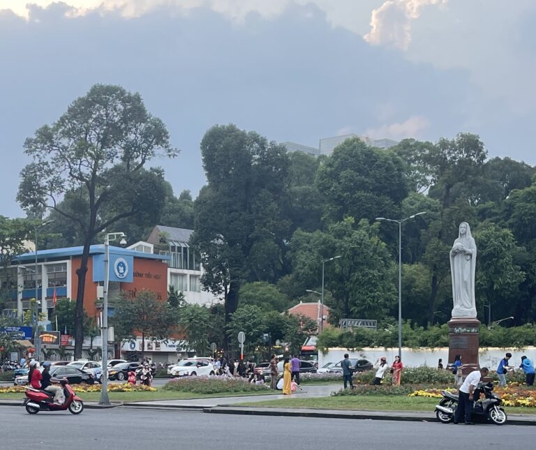 several locals driving on scooters around a roundabout close to sunset in Ho Chi Minh City / Ho Chi Minh City Itinerary 4 days