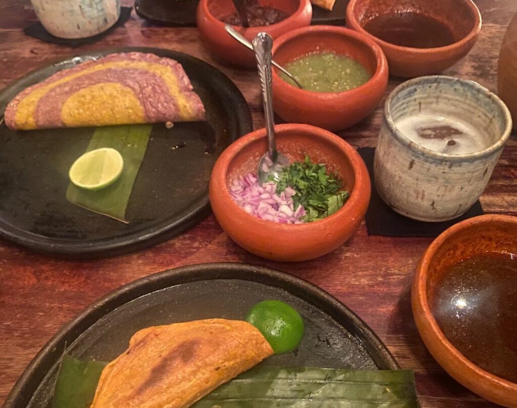 tacos with various salsas being served at Negro Huitlacoxe restaurant in Tulum, Mexico