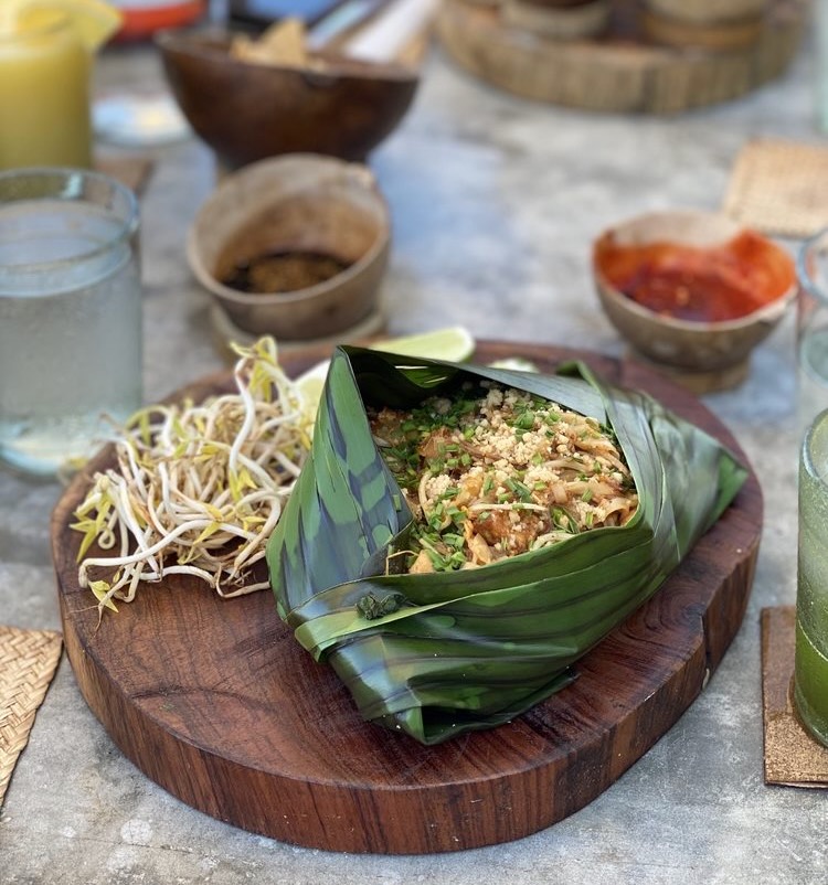 a pad thai chicken being served in a banana leaf at Mezzanine Restaurant in Tulum, Mexico 