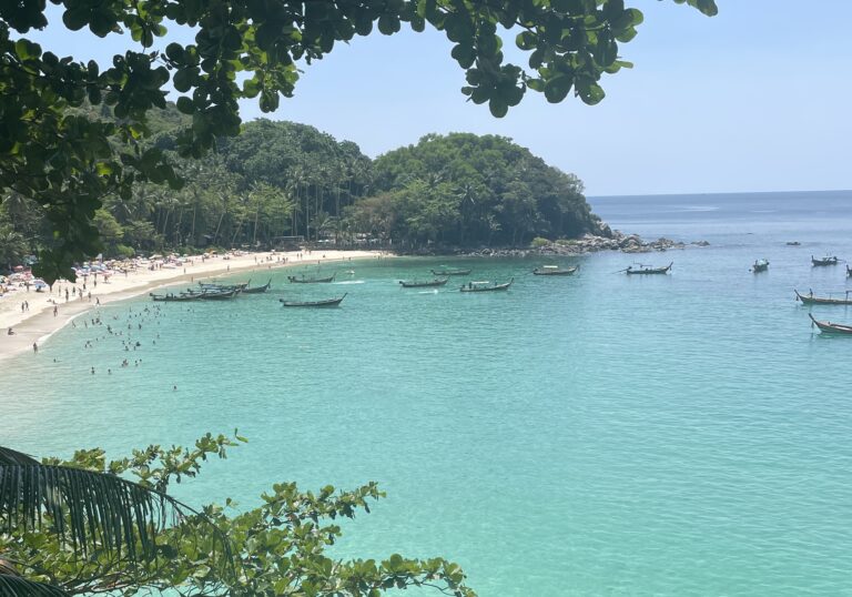 several tourist and Thai longtail boats on the shores of Freedom Beach in Phuket / 7 day itinerary for Phuket