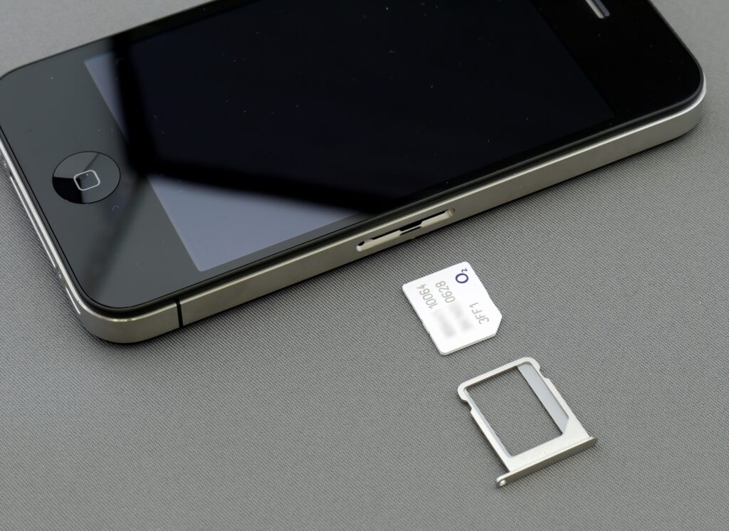 an iphone next to a sim card 