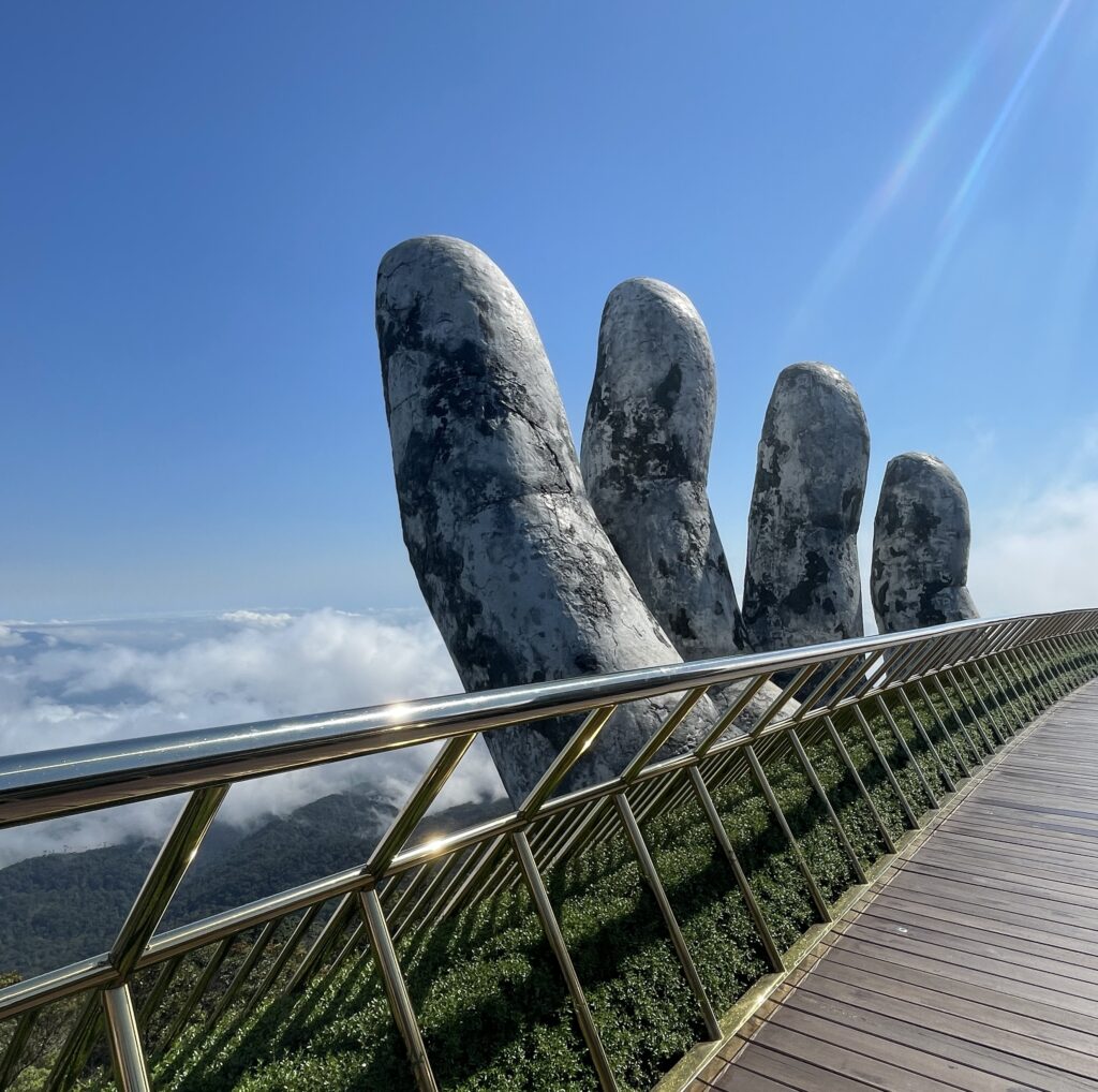 the sun shining on a large hand statue known as the Golden Bridge at the Ba Na Hills in Da Nang, Vietnam
