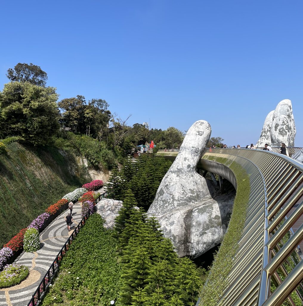 a large floral garden surrounding the Golden Bridge at the Ba Na Hills in Vietnam