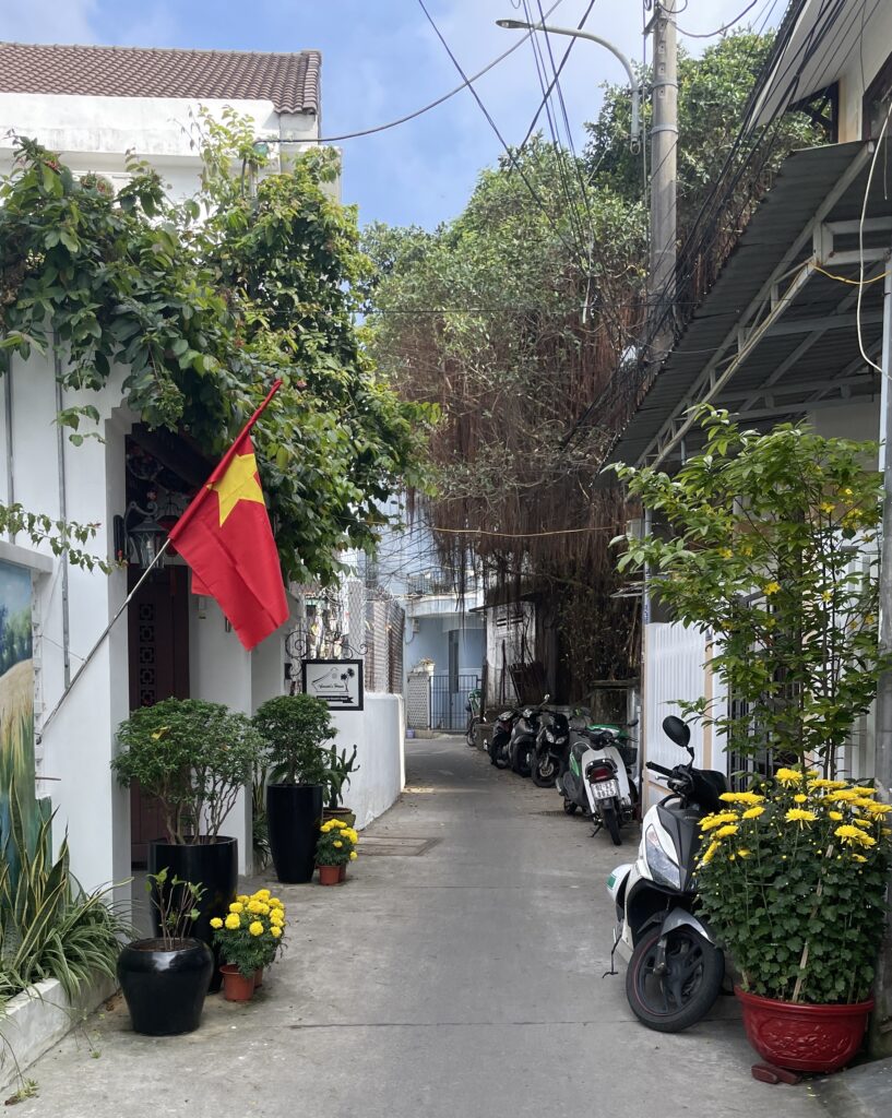 an empty charming alleyway with the Vietnam flag displayed in Hoi An