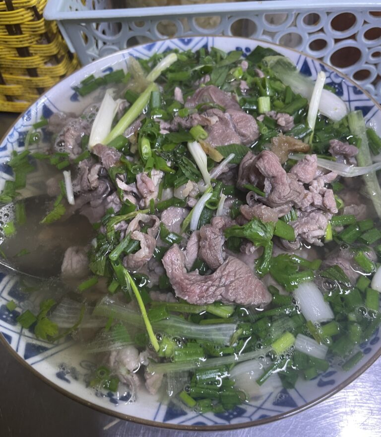 a perfect bowl of pho with thinly sliced beff and spring onions served at a pho restaurant in Hanoi