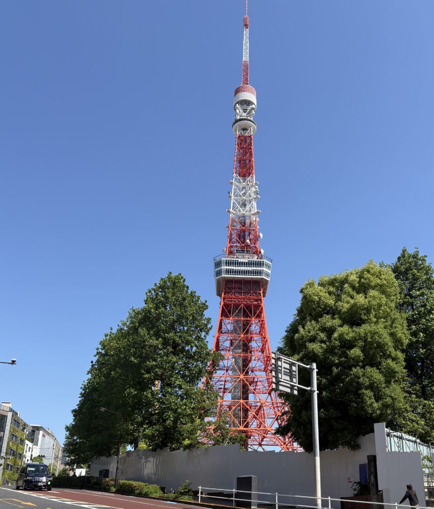 Street view of Tokyo Tower rising above buildings in Roppongi, a lively neighborhood to stay in Tokyo with nightlife and modern art