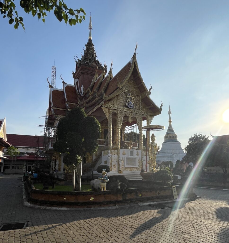 Beautiful temple in Chiang Mai’s Old City near sunset, with the sun shining brightly and casting a golden glow over the architecture.