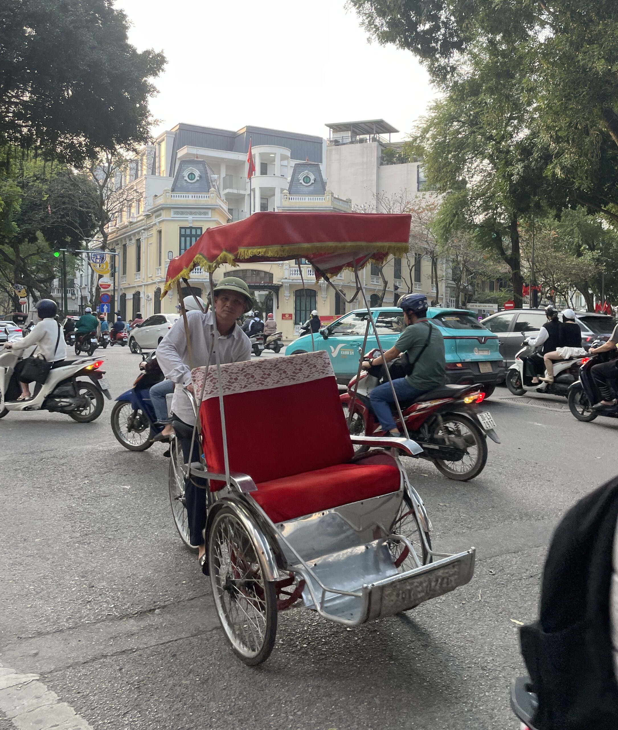 A cyclo driver posing for a photo near Hoan Kiem Lake in Hanoi