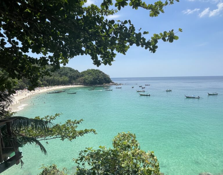 Featured image of multiple boats anchored in the turquoise waters off Freedom Beach in Phuket, Thailand