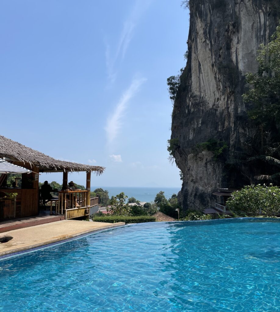 Hilltop infinity pool at a hotel in Railay with limestone cliffs and distant ocean views in Krabi, Thailand