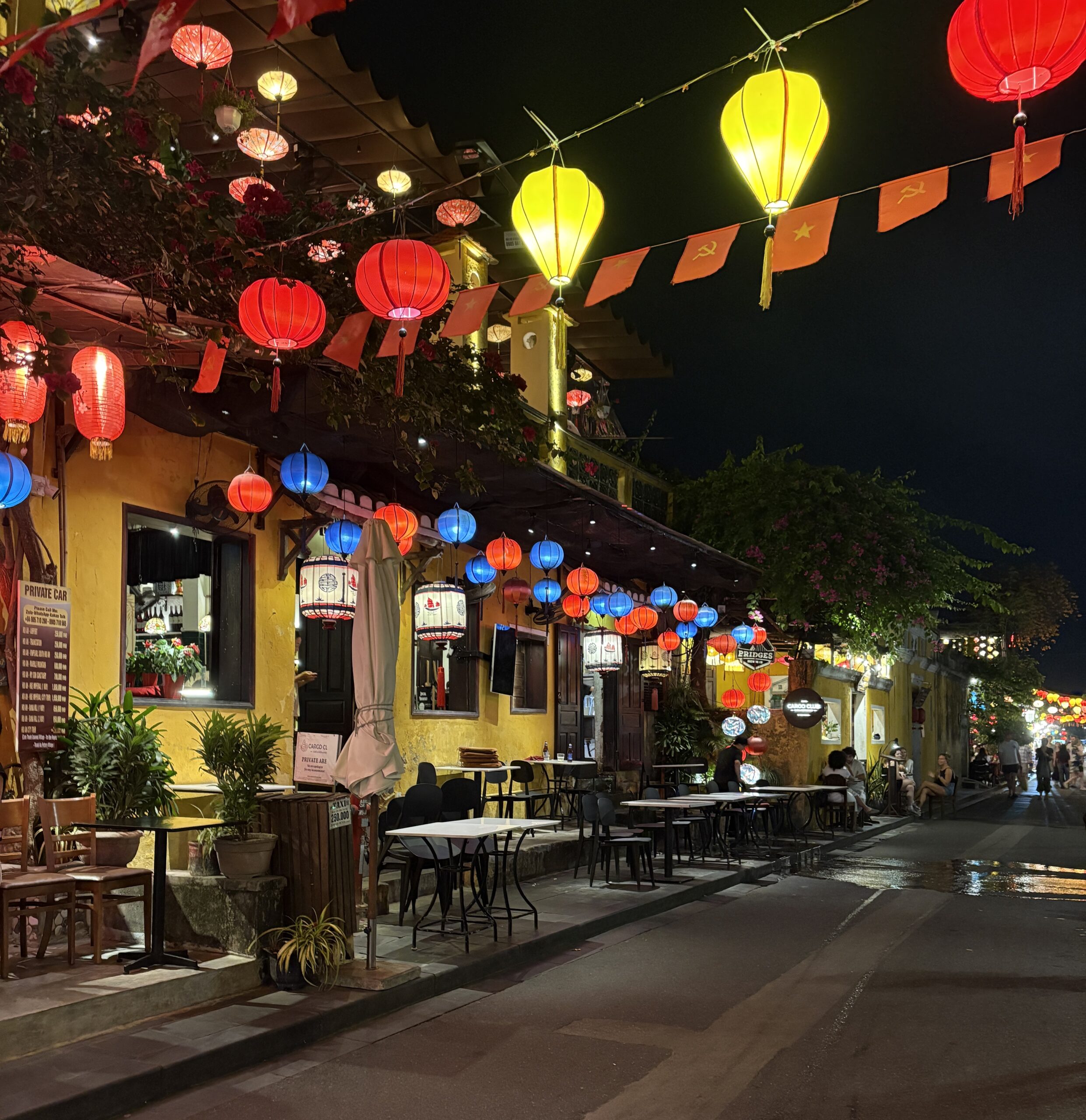 Colorful lanterns hanging outside a restaurant and along the street in Hoi An, Vietnam.